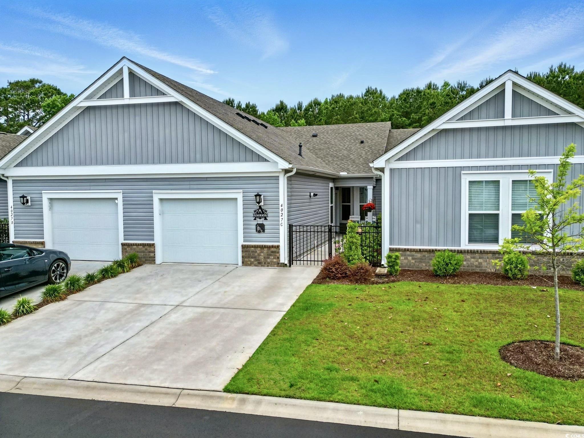 View of front of property with a front yard, board