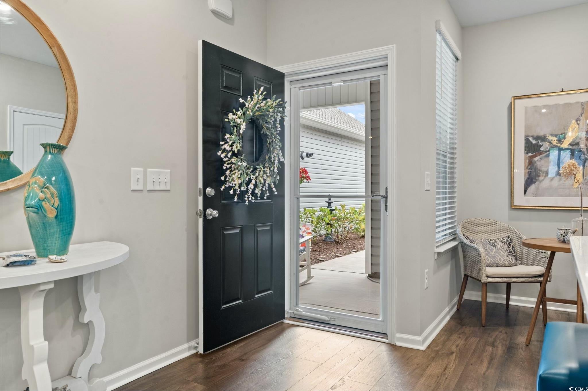 Foyer entrance with dark wood finished floors, hea
