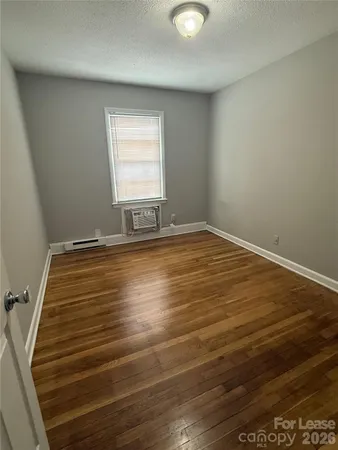 a view of water heater room with wooden floor