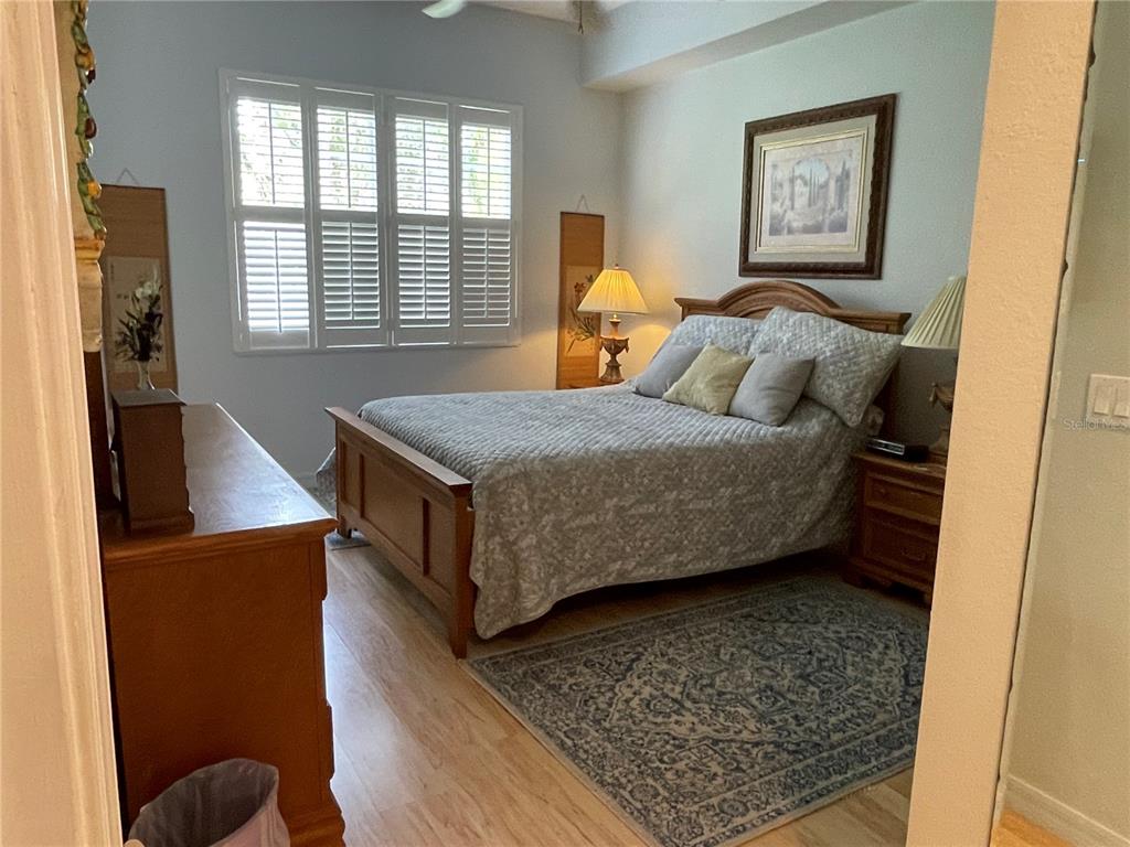 5000 Ibis Way, Unit 101 Venice, FL 34292 - Photo 12 of 39 a bedroom with a bed and wooden floor