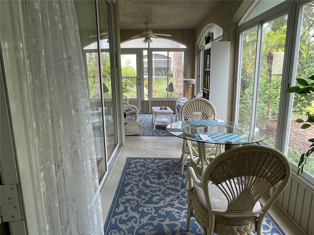 5000 Ibis Way, Unit 101 Venice, FL 34292 - Photo 20 of 39 a living room with furniture and a floor to ceiling window