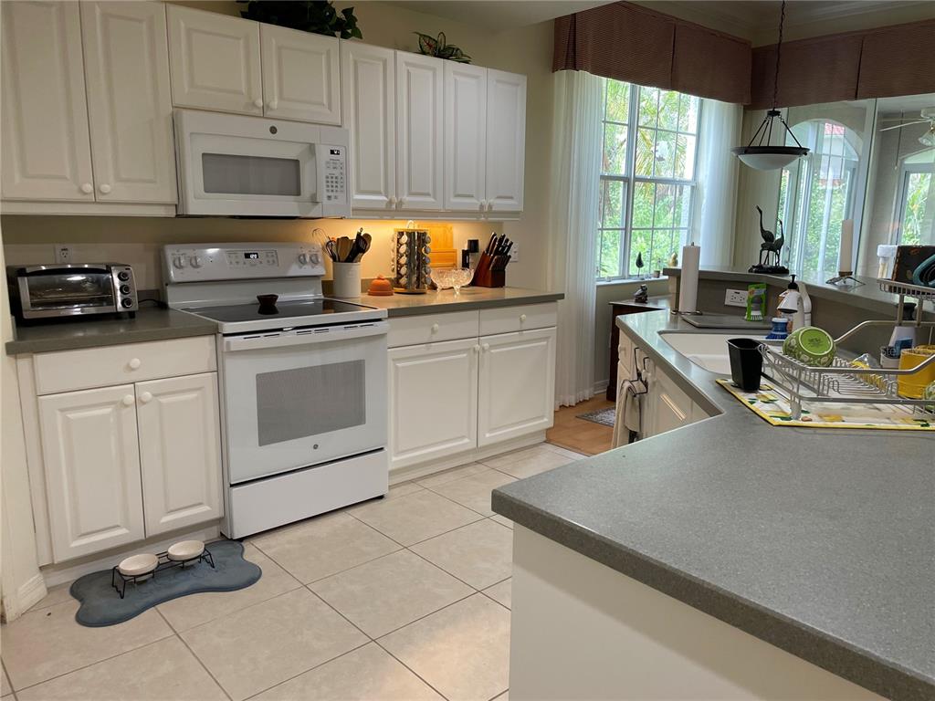 5000 Ibis Way, Unit 101 Venice, FL 34292 - Photo 6 of 39 a kitchen with a sink a stove and cabinets