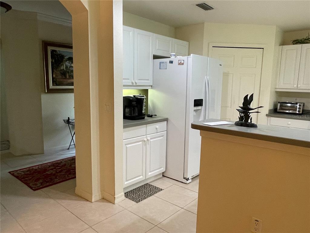 5000 Ibis Way, Unit 101 Venice, FL 34292 - Photo 7 of 39 a kitchen with white cabinets and refrigerator