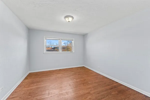 an empty room with a wooden floor and a window