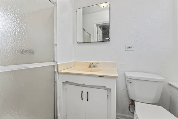 a bathroom with a toilet a sink and mirror