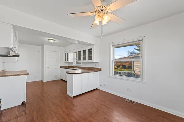 a kitchen with stainless steel appliances granite countertop a sink a stove a refrigerator cabinets and wooden floor