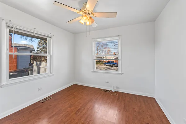an empty room with a window and wooden floor