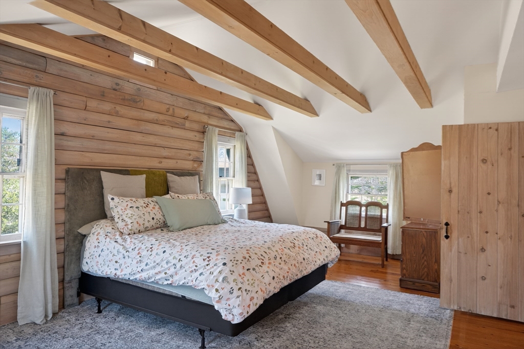 7 Pip'n Road Edgartown, MA 02539 - Photo 16 of 41 a bedroom with a large bed and a chandelier
