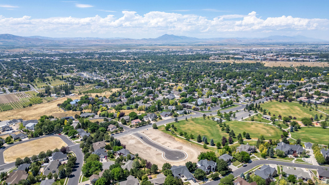 1473 Red Fox Court, Unit 4 Logan, UT 84321 - Photo 8 of 19 Aerial perspective showcasing a developing residential area with established homes, green spaces, and mountain backdrops