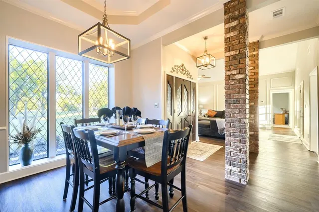 a view of a dining room and livingroom with lots of furniture wooden floor and a chandelier
