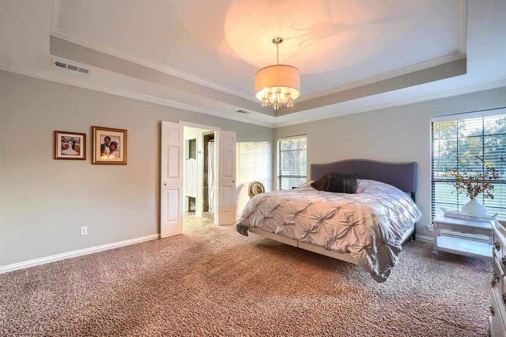 2592 Meadow Way Kaufman, TX 75142 - Photo 17 of 40 a spacious bedroom with a bed and a chandelier