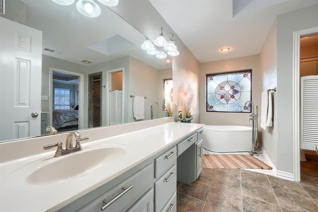 2592 Meadow Way Kaufman, TX 75142 - Photo 20 of 40 a spacious bathroom with a bathtub a sink and a large mirror