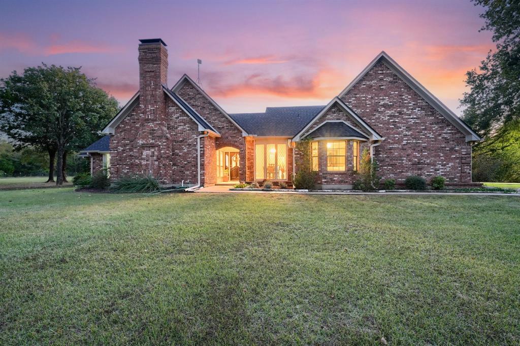 2592 Meadow Way Kaufman, TX 75142 - Photo 2 of 40 a front view of a house with a garden and yard