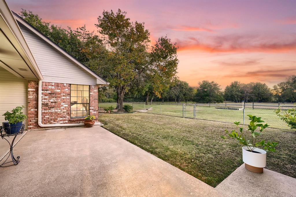 2592 Meadow Way Kaufman, TX 75142 - Photo 32 of 40 a view of a backyard with pathway and a garden