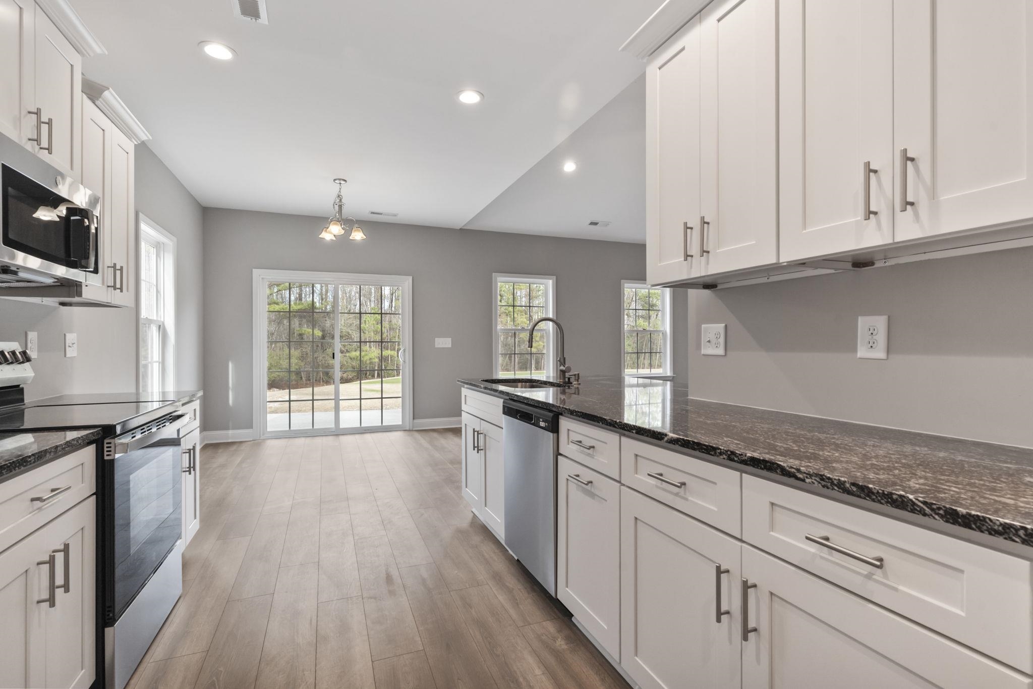 565 Timber Creek Drive Loris, SC 29569 - Photo 22 of 37 Kitchen featuring appliances with stainless steel finishes, white cabinets, dark stone countertops, light wood finished floors, and recessed lighting