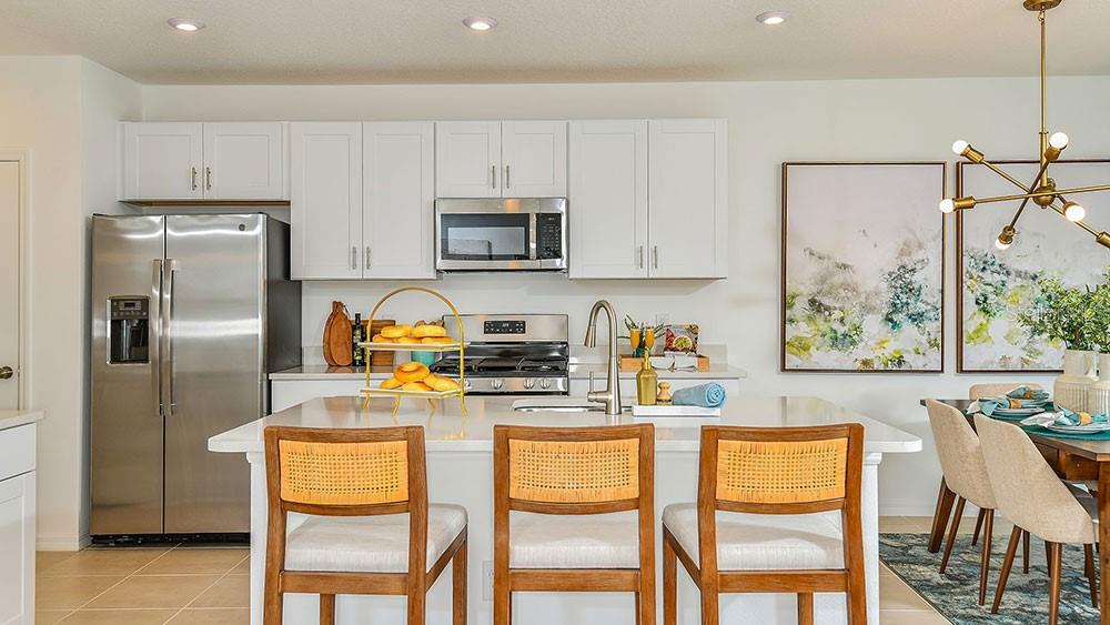 13811 Shellmore Avenue Palmetto, FL 34221 - Photo 11 of 17 a kitchen with stainless steel appliances a dining table chairs refrigerator and sink