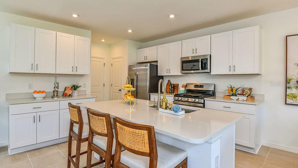 13811 Shellmore Avenue Palmetto, FL 34221 - Photo 17 of 17 a kitchen with a sink a microwave and cabinets