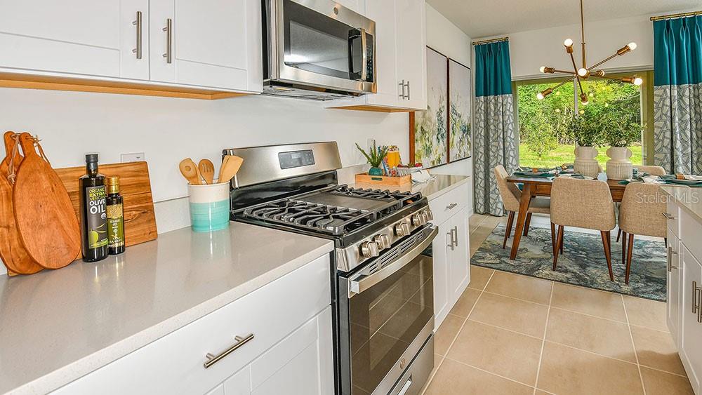 13811 Shellmore Avenue Palmetto, FL 34221 - Photo 8 of 17 a kitchen with stainless steel appliances granite countertop a stove a sink and a microwave