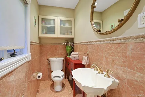 a bathroom with a toilet a sink and a mirror