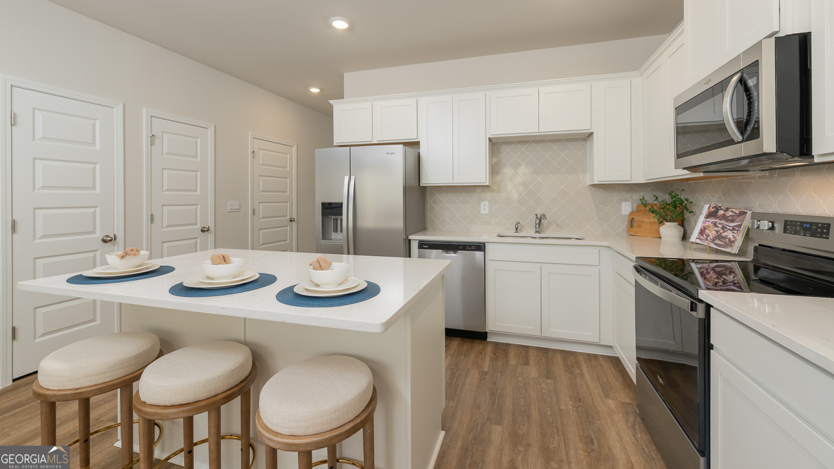 2082 Moss Hill Road Stone Mountain, GA 30088 - Photo 17 of 38 a kitchen with stainless steel appliances granite countertop a sink a stove a table and chairs