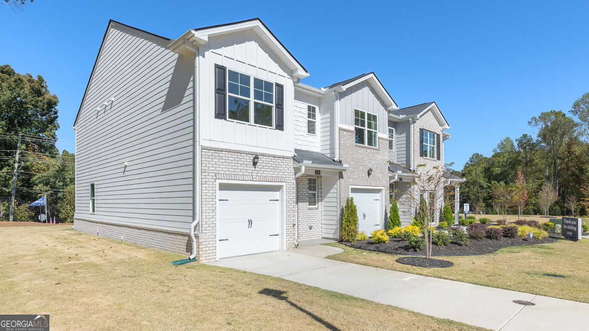 2082 Moss Hill Road Stone Mountain, GA 30088 - Photo 2 of 38 a view of a white house with a yard and garage
