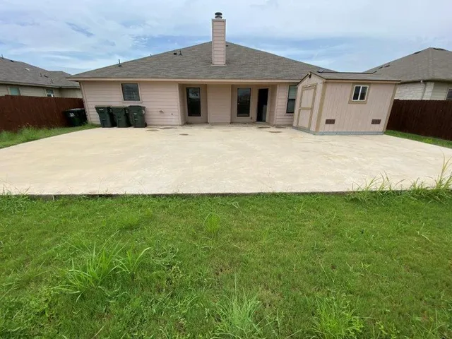a large white house with a big yard and large trees