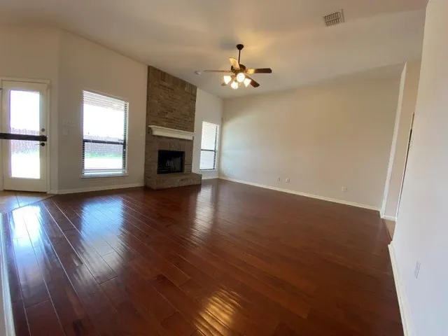 a view of empty room with wooden floor and fireplace