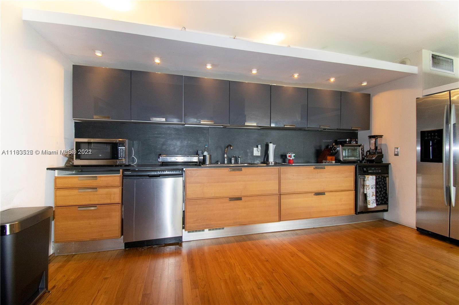 1000 Quayside Terrace, Unit 1205 Miami, FL 33138 - Photo 11 of 12 a kitchen with stainless steel appliances granite countertop a sink a stove a refrigerator and a microwave