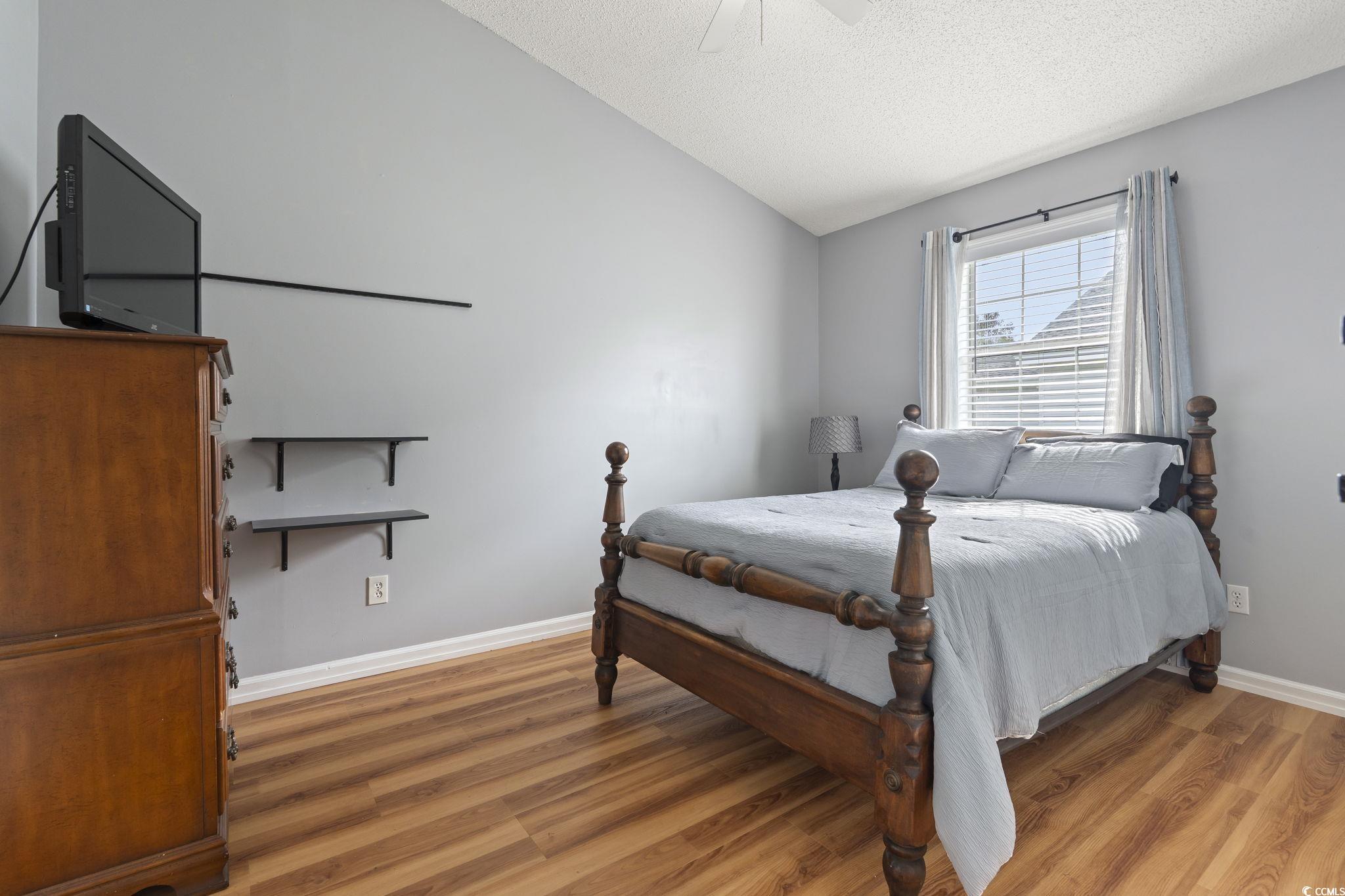 1130 Ganton Way Myrtle Beach, SC 29588 - Photo 15 of 30 Bedroom with light wood-type flooring, baseboards, vaulted ceiling, and a textured ceiling