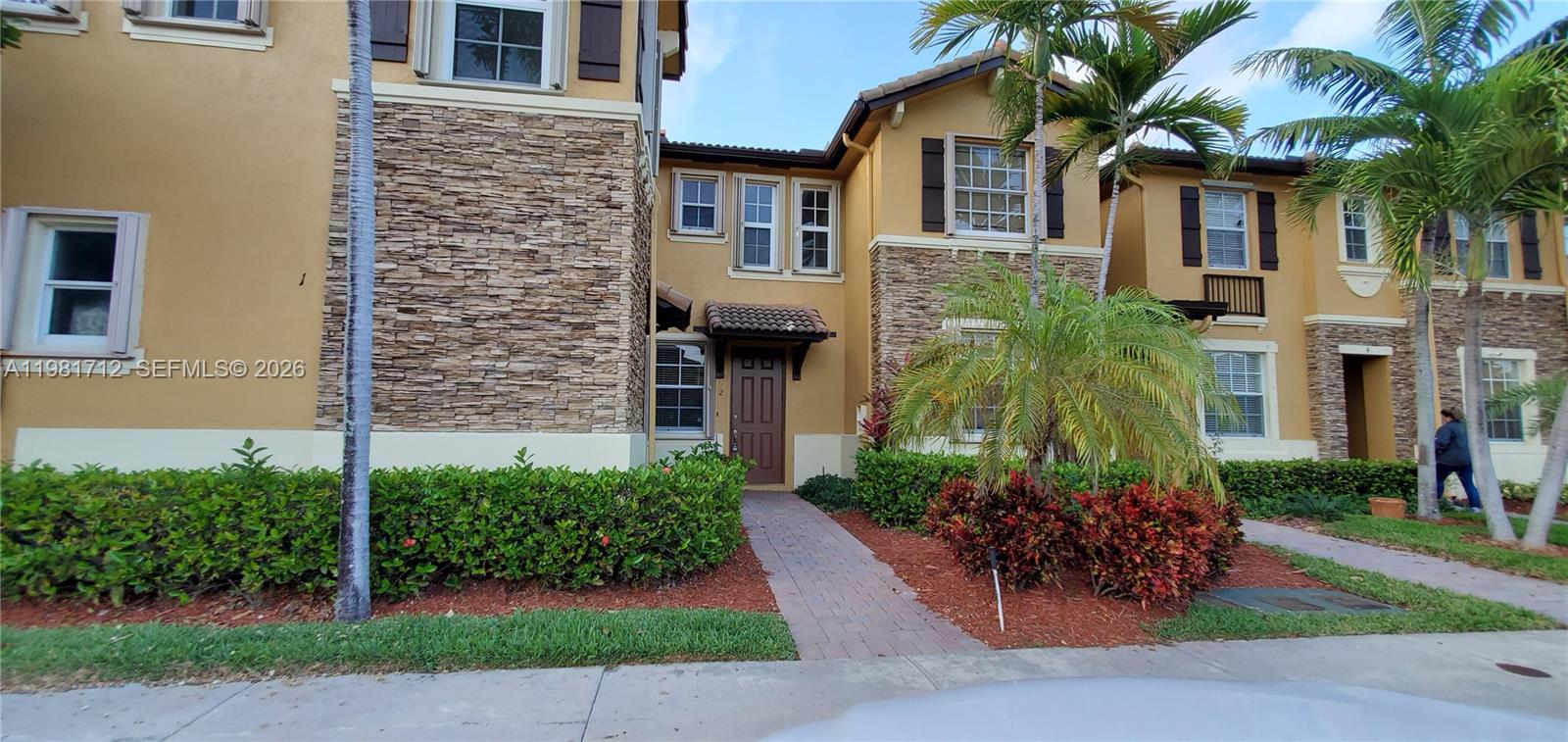 9267 Southwest 227th Street, Unit 2 Miami, FL 33190 - Photo 1 of 24 a front view of a house with a garden