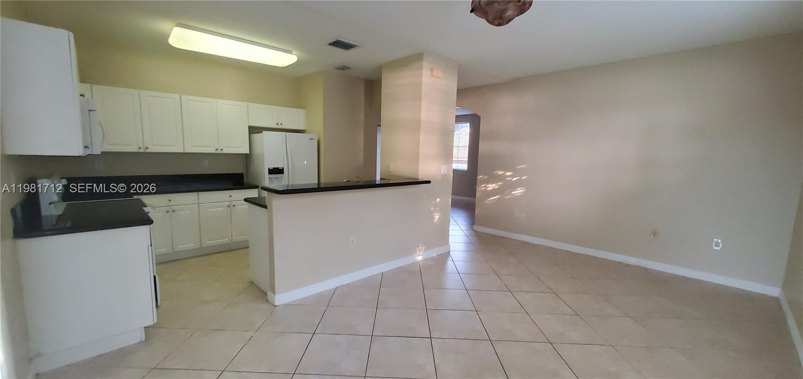9267 Southwest 227th Street, Unit 2 Miami, FL 33190 - Photo 11 of 24 a kitchen with granite countertop a cabinets and a stove top oven