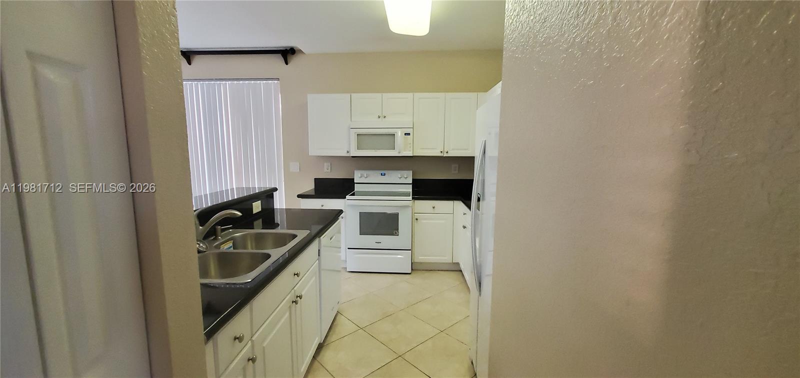 9267 Southwest 227th Street, Unit 2 Miami, FL 33190 - Photo 14 of 24 a kitchen with a sink a stove and refrigerator
