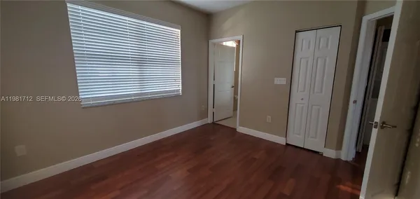 an empty room with wooden floor and a window