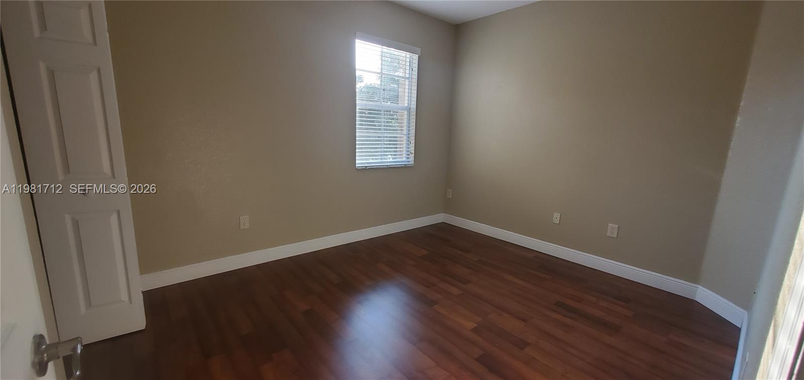 9267 Southwest 227th Street, Unit 2 Miami, FL 33190 - Photo 6 of 24 an empty room with wooden floor and windows