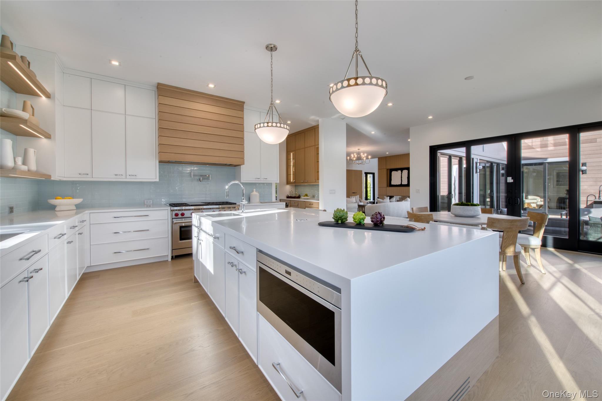158 Cobb Road Water Mill, NY 11976 - Photo 11 of 43 Kitchen featuring open shelves, appliances with stainless steel finishes, a large island, light wood-style floors, and white cabinets
