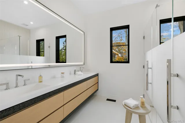 a bathroom with a double vanity sink mirror and toilet