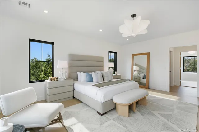 a spacious bedroom with a bed and a chandelier