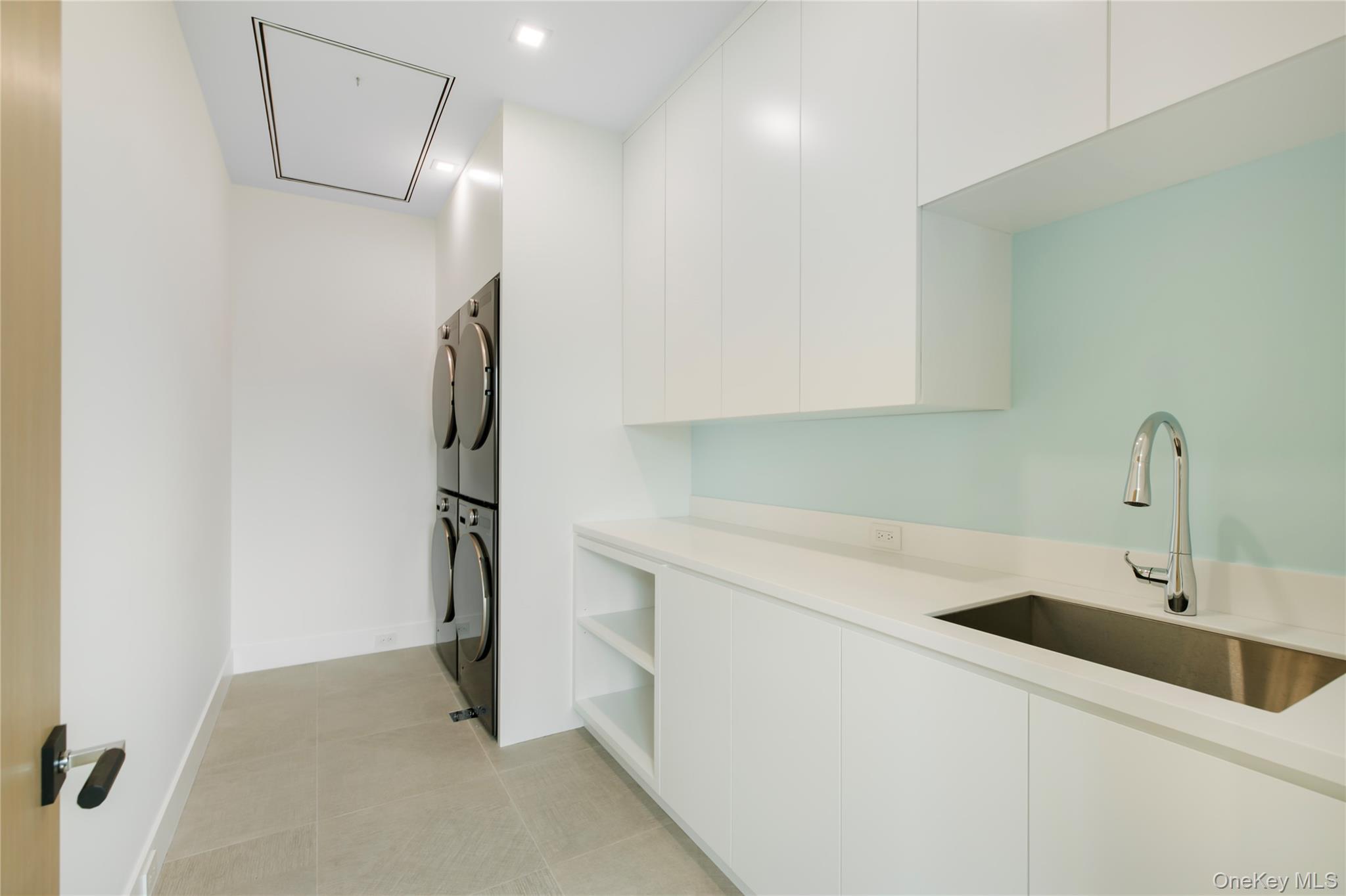 158 Cobb Road Water Mill, NY 11976 - Photo 28 of 43 Laundry area featuring stacked washer / dryer, attic access, light tile patterned floors, and recessed lighting