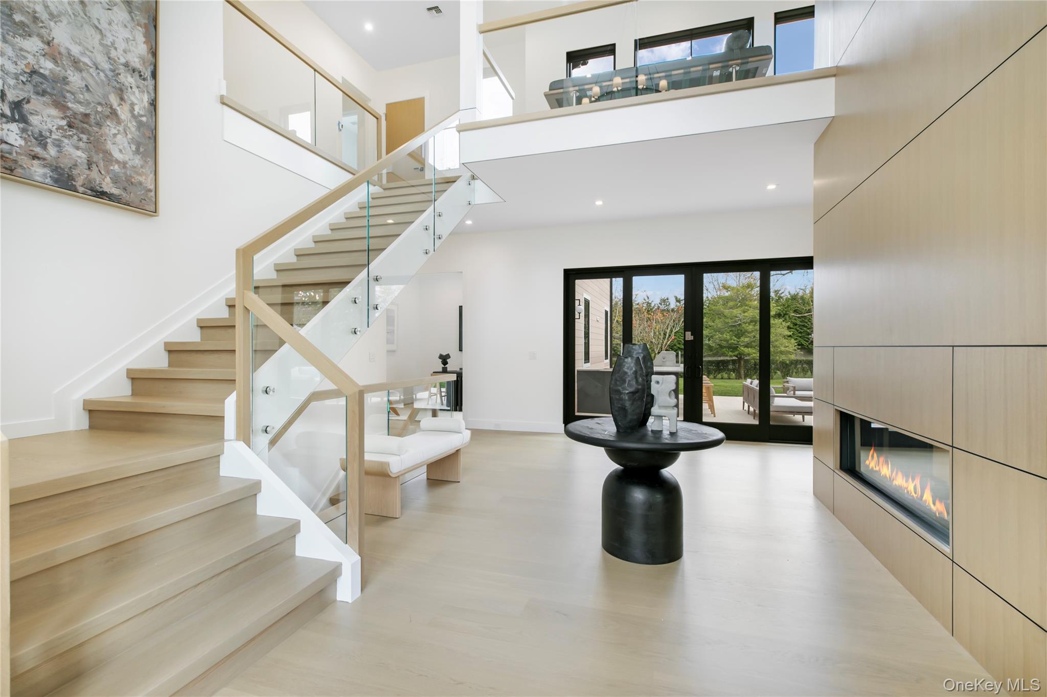 158 Cobb Road Water Mill, NY 11976 - Photo 4 of 43 Stairs featuring a high ceiling, a glass covered fireplace, recessed lighting, and wood finished floors