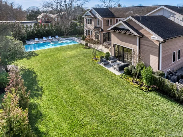 a front view of a house with swimming pool having outdoor seating