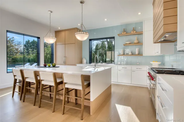 a kitchen with stainless steel appliances granite countertop a stove a sink a microwave a dining table and chairs