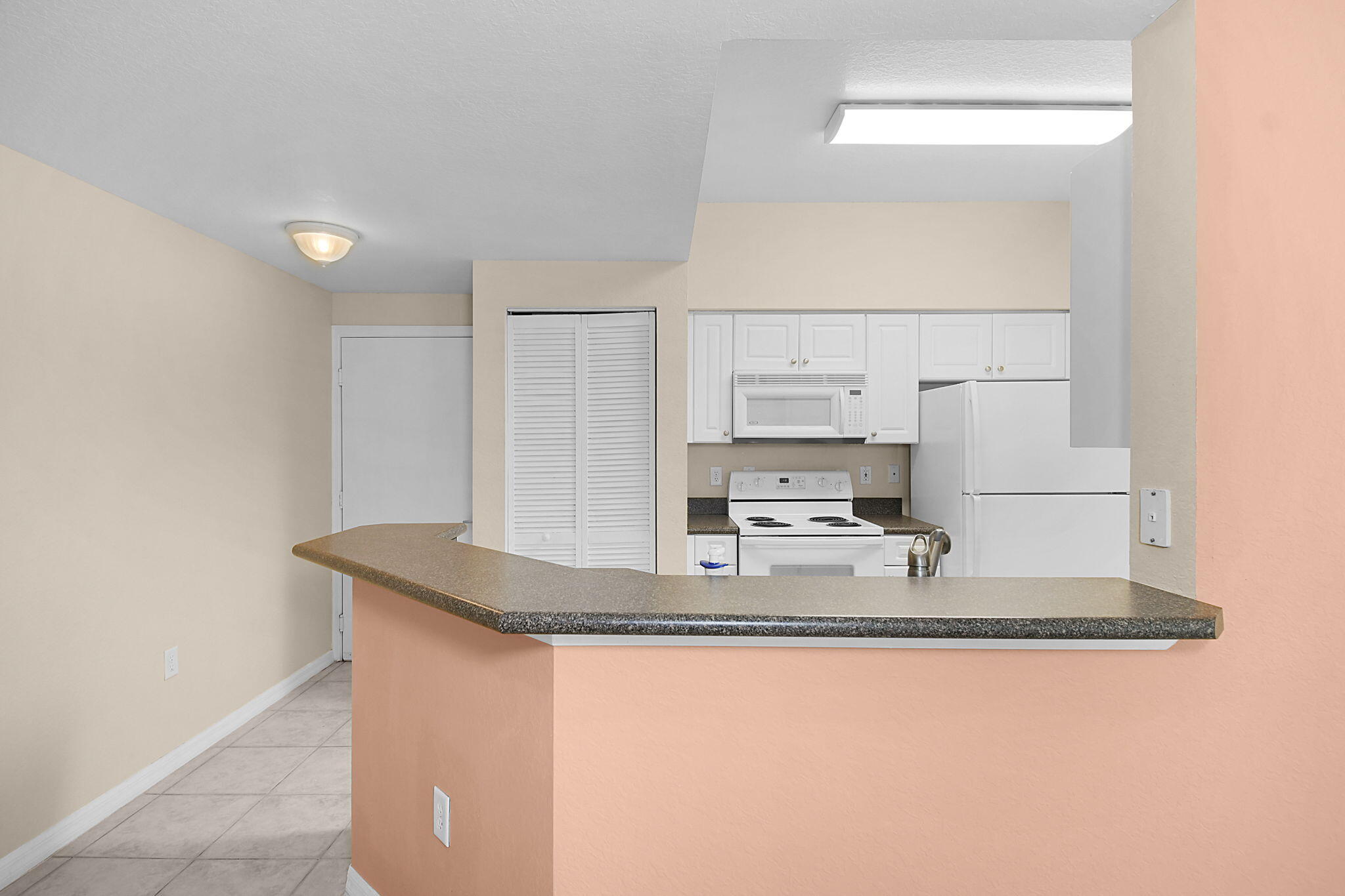 174 Southeast Kitching Circle, Unit 174 Stuart, FL 34994 - Photo 17 of 40 a kitchen with kitchen island granite countertop a sink a counter top space and cabinets