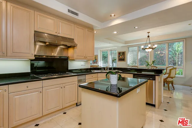 a kitchen with granite countertop a sink white cabinets and window