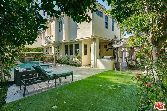 a view of a house with backyard and sitting area