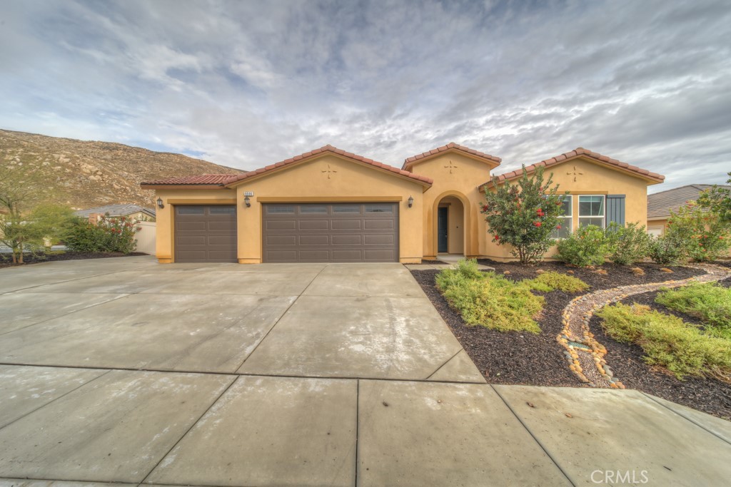 9596 Trailhead Lane Moreno Valley, CA 92557 - Photo 3 of 67 a front view of a house with a garden and plants