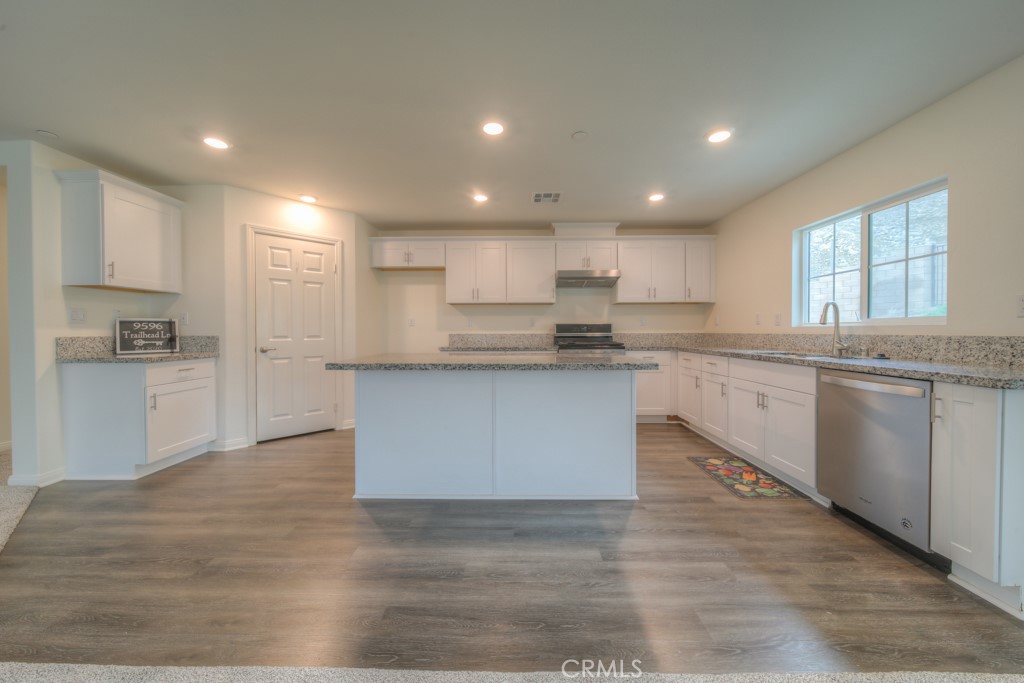 9596 Trailhead Lane Moreno Valley, CA 92557 - Photo 31 of 67 a large kitchen with kitchen island a sink a center island stainless steel appliances and a window