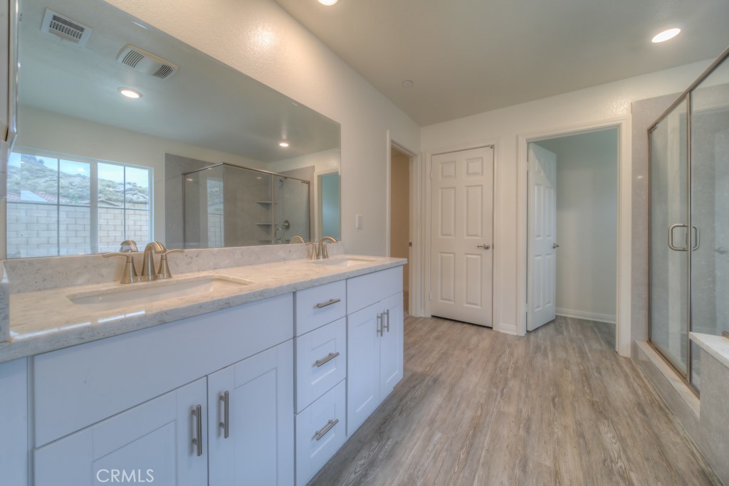 9596 Trailhead Lane Moreno Valley, CA 92557 - Photo 41 of 67 a bathroom with a double vanity sink and mirror