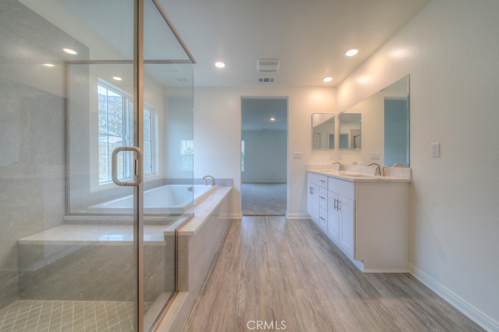 9596 Trailhead Lane Moreno Valley, CA 92557 - Photo 44 of 67 a bathroom with a sink a mirror and shower