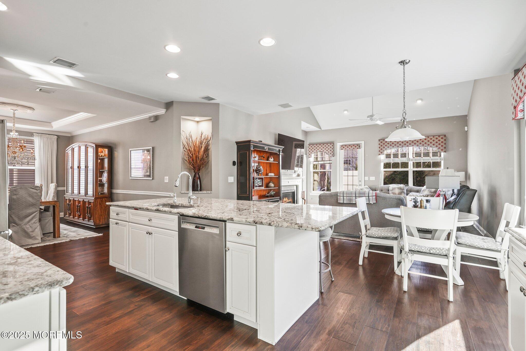 57 Harvest Ridge Road Howell, NJ 07731 - Photo 12 of 39 a kitchen with stainless steel appliances a dining table chairs stove and white cabinets