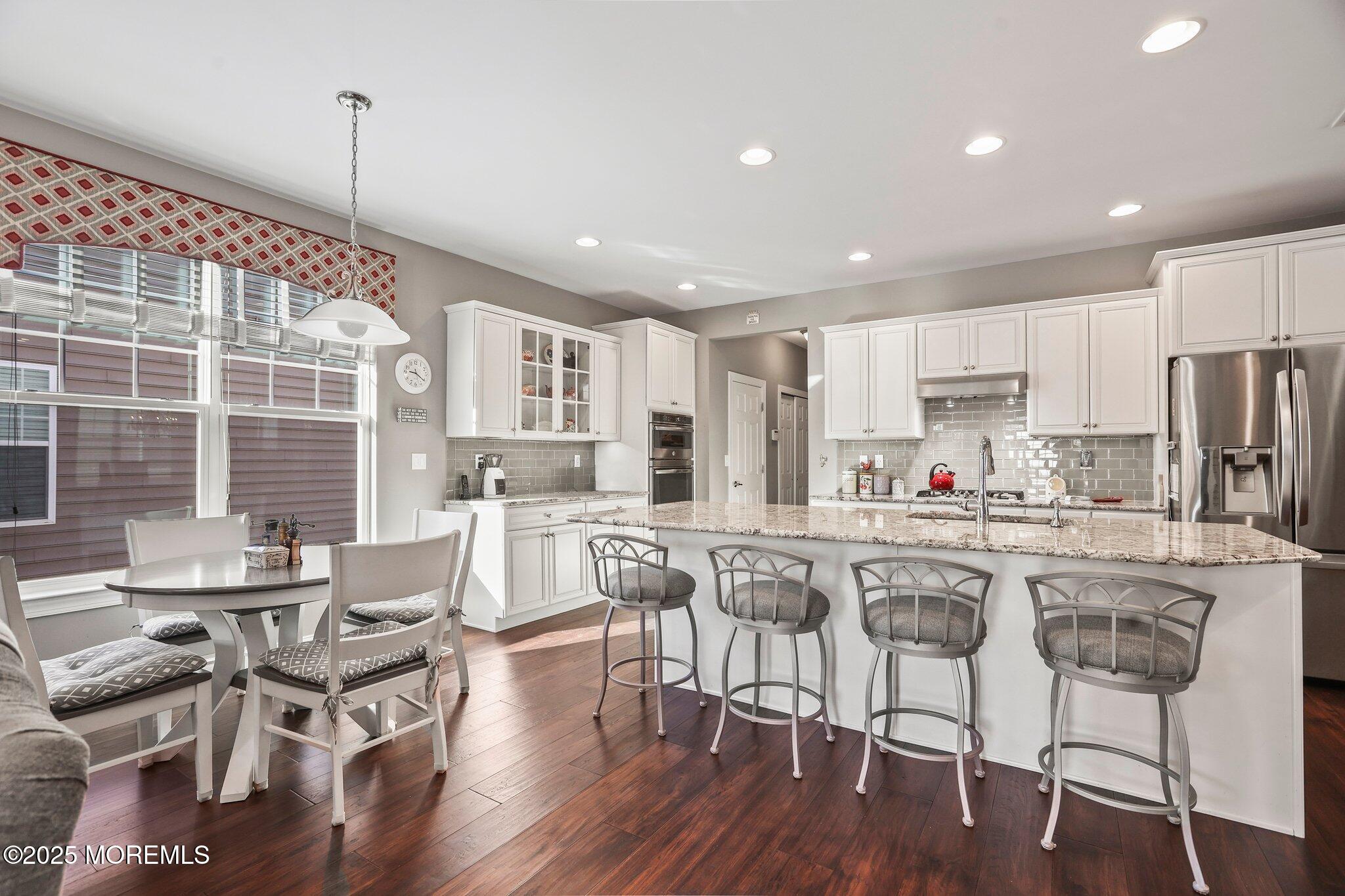57 Harvest Ridge Road Howell, NJ 07731 - Photo 13 of 39 a kitchen with stainless steel appliances granite countertop a dining table chairs refrigerator sink and cabinets